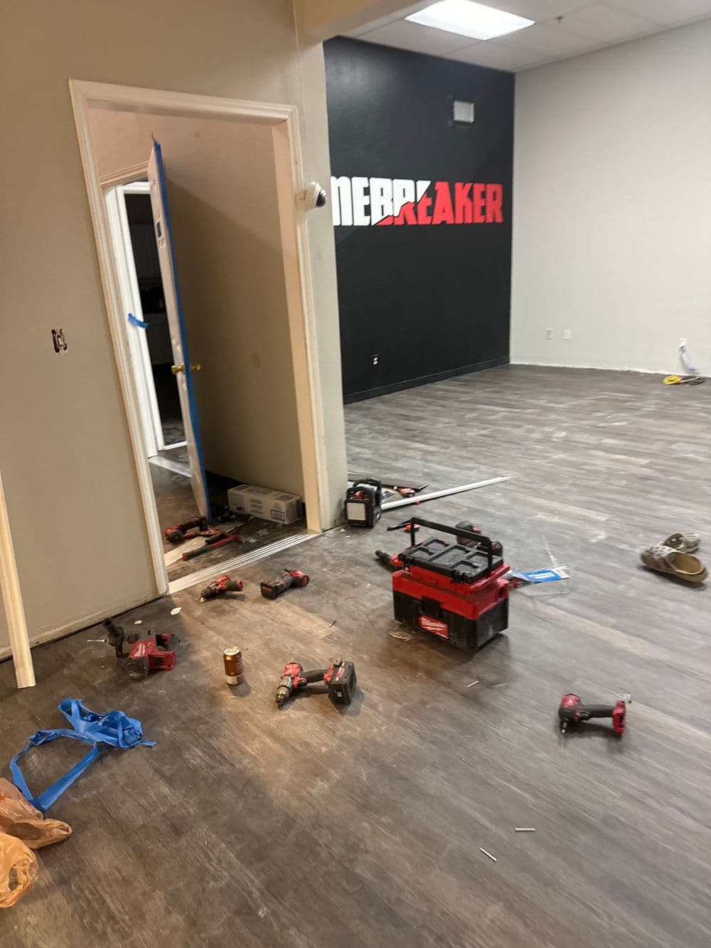 Renovation in progress with tools scattered on the floor and "MERRBREAKER" sign on wall.